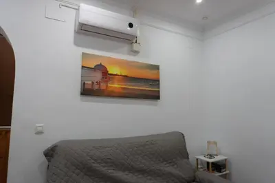 a bedroom with a bed and a picture on the wall at Apartalux Playa La Caleta in Cádiz