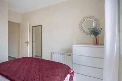 a bedroom with a bed and a mirror and a dresser at Magnifico apartamento en la Barrosa frente al mar in Novo Sancti Petri