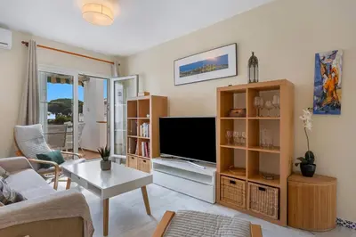 a living room with a couch and a tv at Magnifico apartamento en la Barrosa frente al mar in Novo Sancti Petri