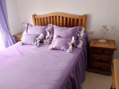 a purple bed with two teddy bears on it at Apartamento Acogedor Centro Playa 2habtn,AA-WIFI-PARKING GRATIS CALLE in Sanlúcar de Barrameda