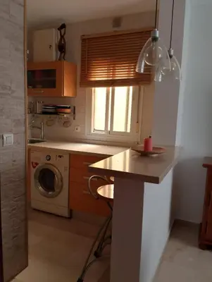 a kitchen with a counter and a washing machine at Apartamento Acogedor Centro Playa 2habtn,AA-WIFI-PARKING GRATIS CALLE in Sanlúcar de Barrameda