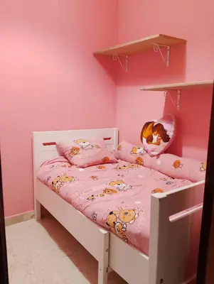 a small bedroom with a bed with a pink wall at Apartamento Acogedor Centro Playa 2habtn,AA-WIFI-PARKING GRATIS CALLE in Sanlúcar de Barrameda