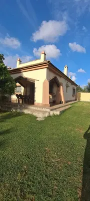 a house with a grass yard in front of it at Casa Bambú de Luna in Chiclana de la Frontera
