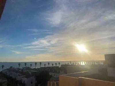 a view of a city with the sun in the sky at Great apartment in Puerto Real in Puerto Real