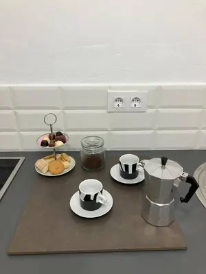a kitchen counter with two cups and plates of food at Charming 1900 Andalusian Apartment in Arcos de la Frontera in Arcos de la Frontera