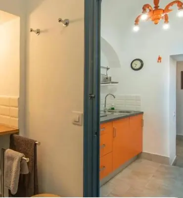 a kitchen with a sink and a clock on the wall at Charming 1900 Andalusian Apartment in Arcos de la Frontera in Arcos de la Frontera