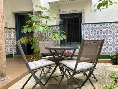 two chairs and a table in front of a house at Charming 1900 Andalusian Apartment in Arcos de la Frontera in Arcos de la Frontera