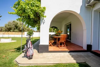 a patio with a table and chairs in a yard at Jardines Fenicios Luxurious and Spacious Villa in Novo Sancti Petri