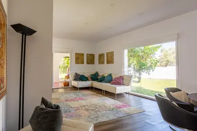 a living room with a couch and a large window at Jardines Fenicios Luxurious and Spacious Villa in Novo Sancti Petri