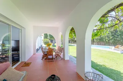 an open living room with a table and chairs at Jardines Fenicios Luxurious and Spacious Villa in Novo Sancti Petri