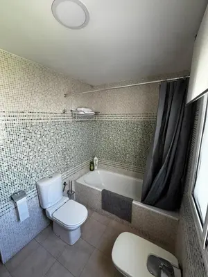 a bathroom with a toilet and a bath tub at Velo de Flor Jerez Apartment in Jerez de la Frontera