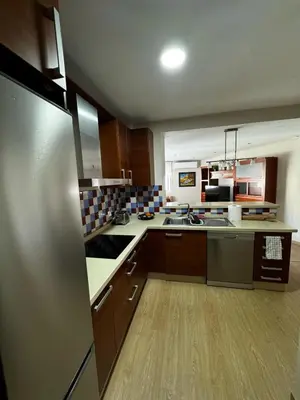 a kitchen with wooden cabinets and stainless steel appliances at Velo de Flor Jerez Apartment in Jerez de la Frontera