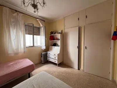 a bedroom with a bed and a dresser and a window at San José Playa Family Home in Cádiz