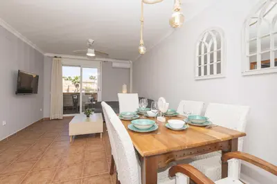 a dining room with a wooden table and chairs at Novo Golf Chiclana in Chiclana de la Frontera