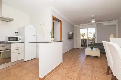 a kitchen with white appliances and a living room at Novo Golf Chiclana in Chiclana de la Frontera