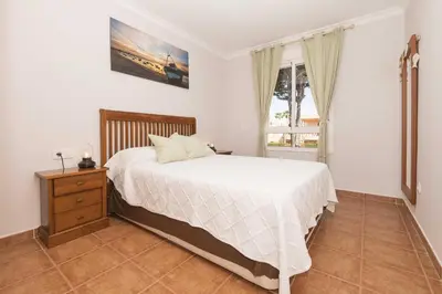 a bedroom with a large bed and a window at Novo Golf Chiclana in Chiclana de la Frontera