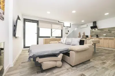 a large bedroom with a bed and a kitchen at Apartamento Tom-Isi in Rota