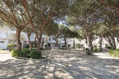 a park with trees in front of a building at Estribor in Poblado de Sancti Petri
