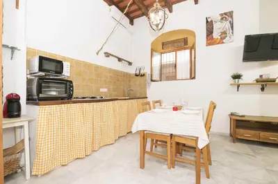 a kitchen with a table with chairs and a microwave at Loft Santiago in Jerez de la Frontera