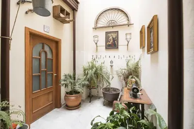 a hallway with potted plants and a wooden door at Loft Santiago in Jerez de la Frontera