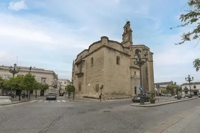 an old stone building with a tower on a street at Loft Santiago in Jerez de la Frontera