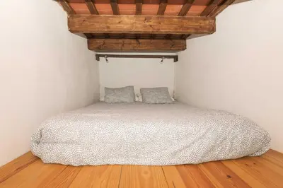 a bed in a room with a wooden ceiling at Loft Santiago in Jerez de la Frontera