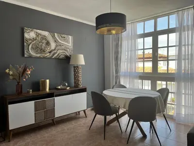 a dining room with a table and chairs and a window at Apartamento Luz de Chiclana by Come2Cádiz in Chiclana de la Frontera