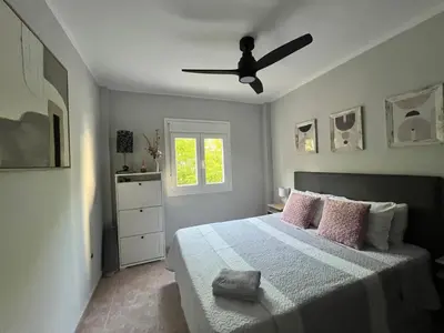 a bedroom with a bed with a ceiling fan at Apartamento Luz de Chiclana by Come2Cádiz in Chiclana de la Frontera