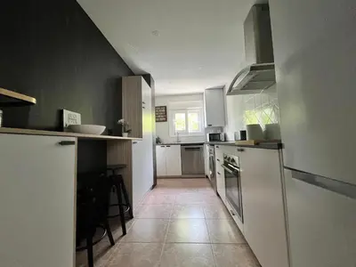 a kitchen with white appliances and a tile floor at Apartamento Luz de Chiclana by Come2Cádiz in Chiclana de la Frontera