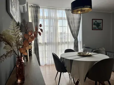 a dining room with a table and chairs and a window at Apartamento Luz de Chiclana by Come2Cádiz in Chiclana de la Frontera