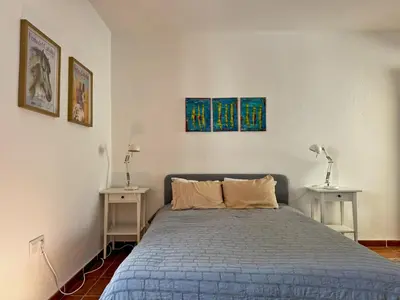 a bedroom with a bed and two tables with lamps at Casa Alba de Abades - Ole Solutions in Jerez de la Frontera
