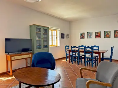 a living room with a table and chairs and a tv at Casa Alba de Abades - Ole Solutions in Jerez de la Frontera
