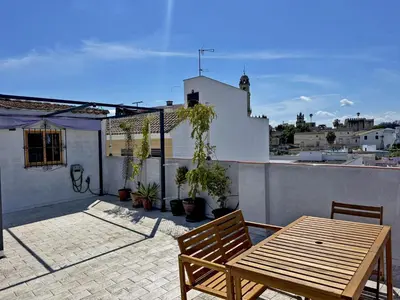 a wooden table and bench on a balcony at Casa Alba de Abades - Ole Solutions in Jerez de la Frontera