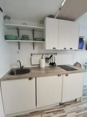 a kitchen with white cabinets and a sink at Apartamento con terraza privada in Jerez de la Frontera
