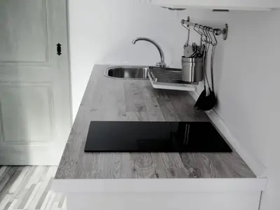 a kitchen with a sink and a wooden floor at Apartamento con terraza privada in Jerez de la Frontera