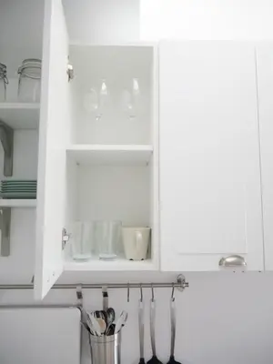 a white kitchen cabinet with dishes and utensils at Apartamento con terraza privada in Jerez de la Frontera