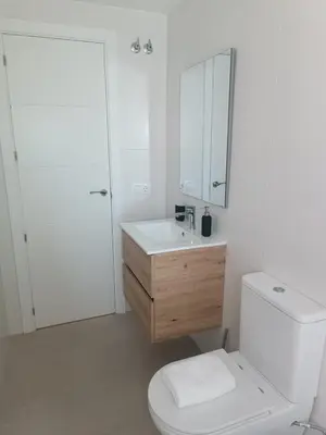 a white bathroom with a toilet and a sink at Apartamento La Bota in Jerez de la Frontera