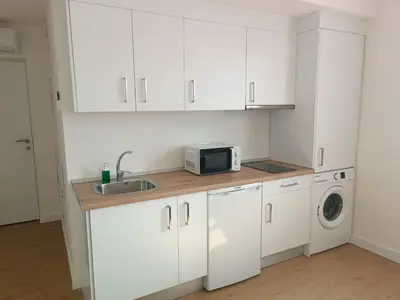 a kitchen with white cabinets and a sink and a microwave at Apartamento La Bota in Jerez de la Frontera