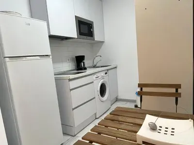 a kitchen with a white refrigerator and a washing machine at Apartamento Canalejas in Cádiz