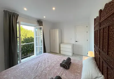a bedroom with a large bed and a large window at Apartamento Canalejas in Cádiz
