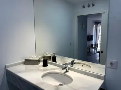 a bathroom with a sink and a large mirror at Apartamento Canalejas in Cádiz