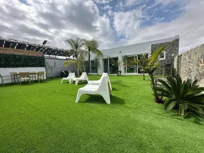 a lawn with white chairs and tables on it at Villa Rural Nuestro Rincón in Sanlúcar de Barrameda