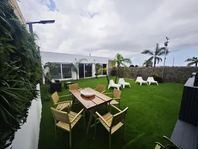 a backyard with a wooden table and chairs at Villa Rural Nuestro Rincón in Sanlúcar de Barrameda