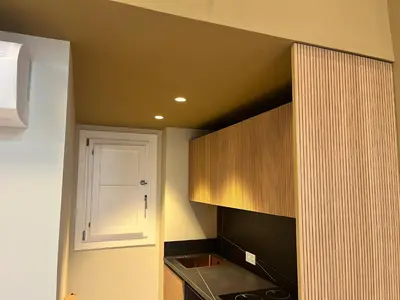 a kitchen with wooden cabinets and a white door at Torre Camelia Adults recommended in Cádiz