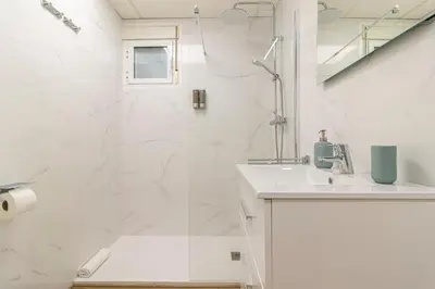 a white bathroom with a shower and a sink at Allo Apartments Balderrama Parking Centro 1 Habitación in Jerez de la Frontera