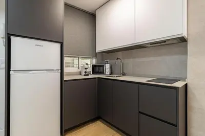 a kitchen with a refrigerator and a sink at Allo Apartments Balderrama Parking Centro 1 Habitación in Jerez de la Frontera