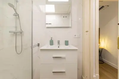 a white bathroom with a sink and a shower at Allo Apartments Balderrama Parking Centro 1 Habitación in Jerez de la Frontera