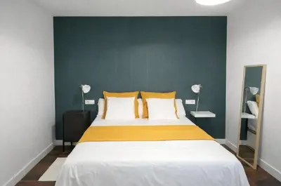 a bedroom with a bed with yellow and white pillows at Solera y Mar, Apartamentos Living Sur in Sanlúcar de Barrameda
