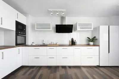 a kitchen with white cabinets and a white refrigerator at Solera y Mar, Apartamentos Living Sur in Sanlúcar de Barrameda