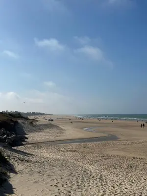 a beach with people walking on the sand at Eleven Views in Chipiona